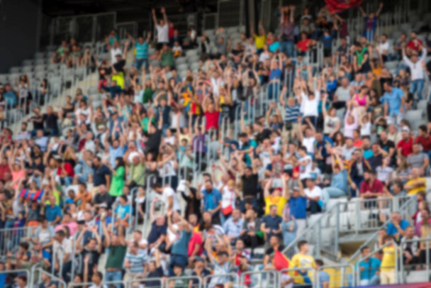 サッカーの試合でスタジアム トリビューンでの観客のぼやけている群衆 - 写真・画像