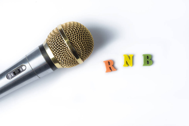 Μικρόφωνο σε λευκό φόντο με τα λόγια Rnb από χρωματιστά γράμματα. - Φωτογραφία, εικόνα