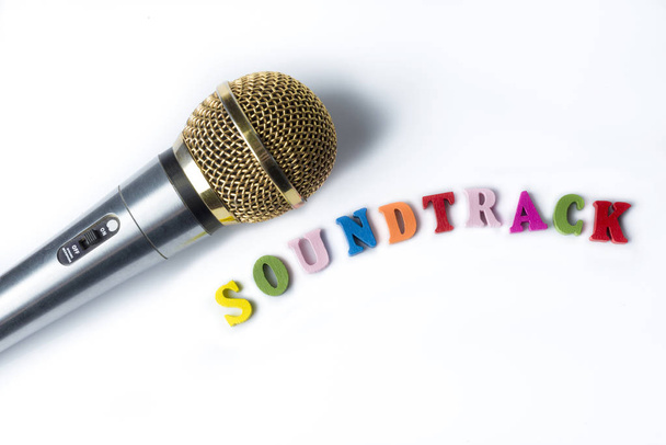 Microphone sur fond blanc avec des mots bande sonore de lettres colorées
. - Photo, image