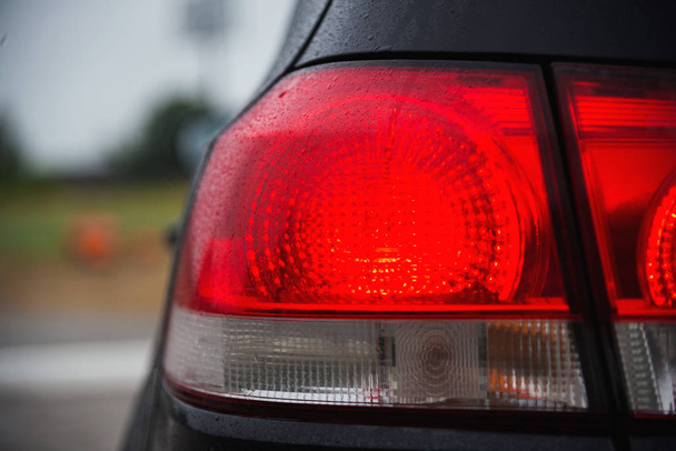 Черный спортивный автомобиль хэтчбек заднее освещение после дождя coseup
 - Фото, изображение