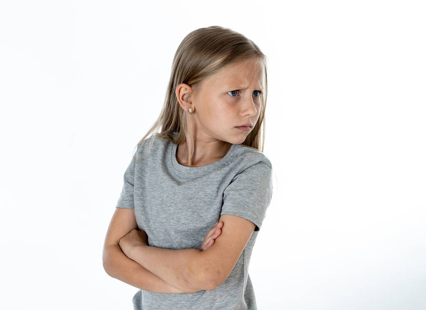Portrait of angry, sad and depressed little blonde girl isolated on white background. Child's face emotions concept - Photo, image
