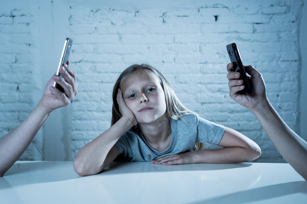 mother and father using mobile phones neglecting little sad ignored daughter bored and lonely feeling abandoned and disappointed with  parents.  mobile cell smart phone addiction bad behavior concept - Foto, imagen