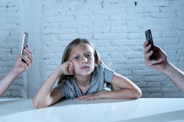mother and father using mobile phones neglecting little sad ignored daughter bored and lonely feeling abandoned and disappointed with  parents.  mobile cell smart phone addiction bad behavior concept - Fotó, kép