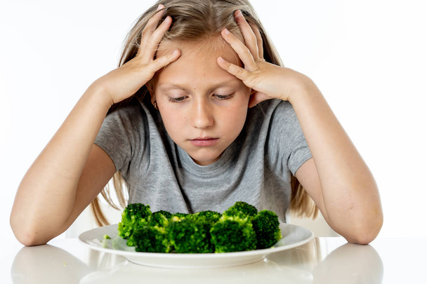 Nutrition and  healthy eating habits for kids healthy eating concept. Children do not like to eat vegetables. Little cute kid girl refuse to eat healthy broccoli  on a white background - Foto, Bild
