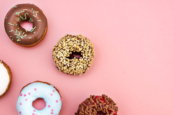 Set of donuts covered with glaze on pink background - Foto, imagen