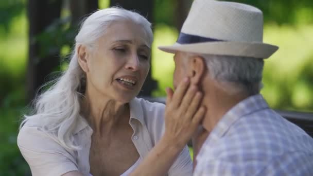 Happy senior woman cuddling with husband outdoors - Footage, Video