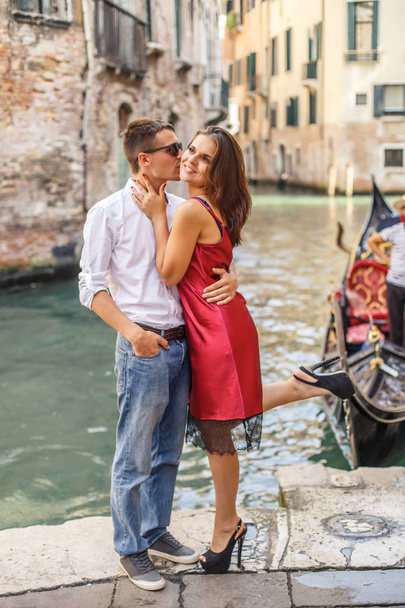 Young man embracing his girlfriend on quay of canal in Venice - Fotoğraf, Görsel