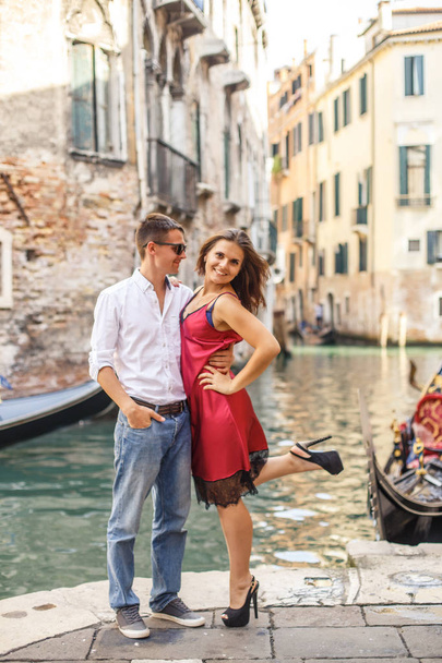 Young man embracing his girlfriend on quay of canal in Venice - Φωτογραφία, εικόνα