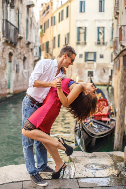 Young man embracing his girlfriend on quay of canal in Venice - Valokuva, kuva