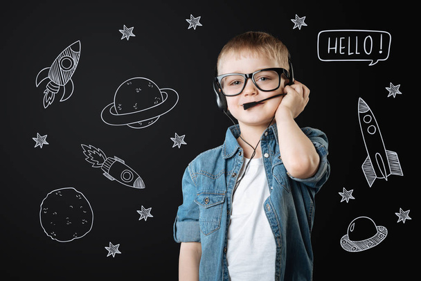Clever boy wearing headphone ad dreaming about space flights - Fotó, kép