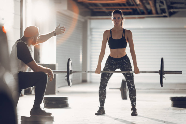 Jovem mulher muscular fazendo cross workout com personal trainer
 - Foto, Imagem