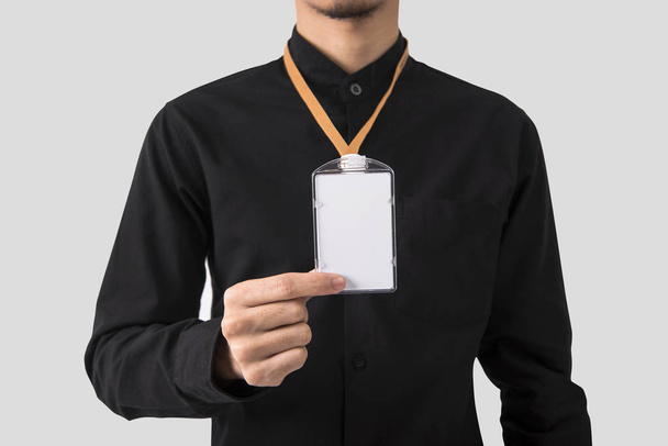 mano del empleado que muestra el titular de la insignia de la tarjeta de identificación en blanco para el fondo de marca del logotipo de la plantilla de maqueta. - Foto, Imagen
