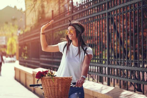 junge Frau radelt an sonnigem Sommertag auf der Stadtstraße - Foto, Bild