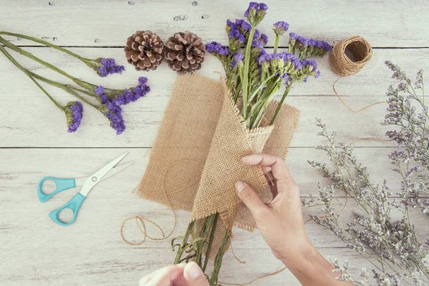 Вид зверху рука жінки флориста створює букет квітів на настільному магазині
. - Фото, зображення