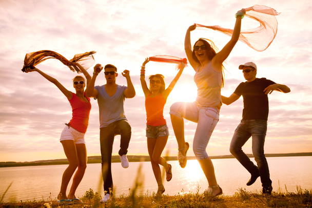 Skupina happy mladých lidí tančí na krásné letní západ slunce na pláži - Fotografie, Obrázek
