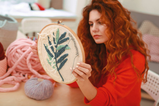 Enthusiastic young girl embroidering little branch - Foto, imagen