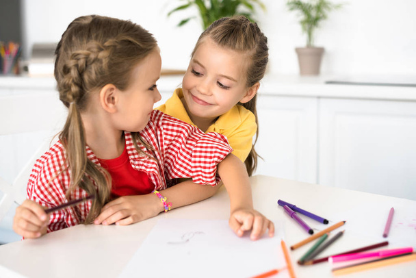 portrait of cute little children at table with papers and pencils for drawing at home - Photo, Image