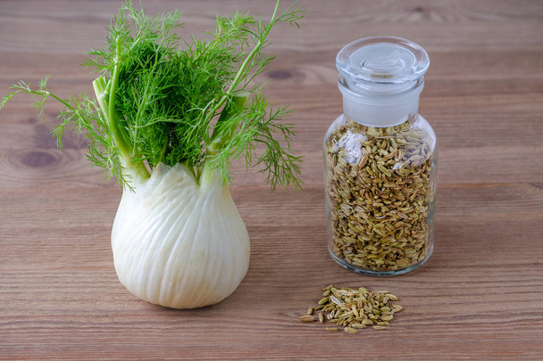 fennel bulb and seeds in a glass jar on brown wooden background - Photo, Image