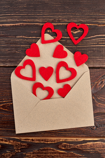 Opened envelope and red paper hearts. - Фото, изображение
