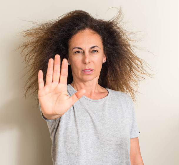 Zwinięte włosy kobieta brazylijski z otwartej dłoni robi znak stop z poważnych i pewnie wyrażenie, obrony gest - Zdjęcie, obraz