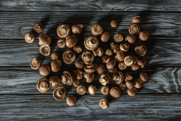top view of pile of raw brown champignon mushrooms on wooden surface - Photo, image