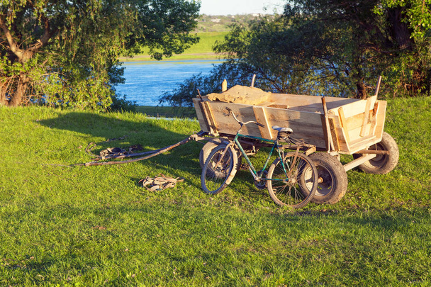 carriage and bicycle on the green meadow  - Fotó, kép
