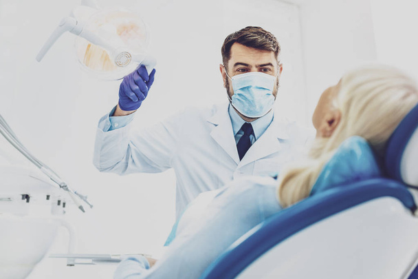 Delighted dentist treating his patient - 写真・画像