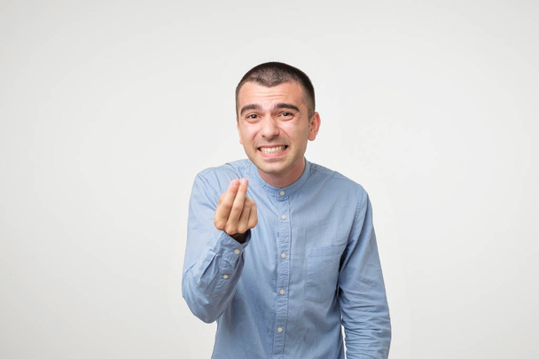 Attractive italian guy looking mad and angry pointing gesture with one hand. To utter extreme irritation and discontent. Body language. Claim business partner concept - Photo, Image
