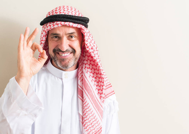 Homem árabe sênior fazendo sinal ok com os dedos, excelente símbolo
 - Foto, Imagem