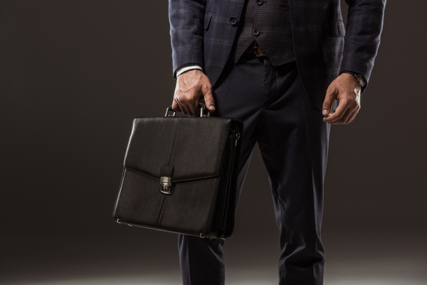 cropped shot of businessman holding briefcase on black - Zdjęcie, obraz