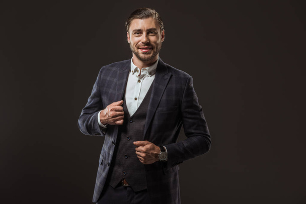 portrait of handsome stylish man in formal wear smiling at camera isolated on black - Zdjęcie, obraz