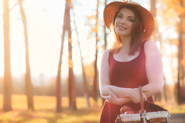 Uma rapariga de chapéu a passear no parque. Uma menina com um passeio de cesta
 - Foto, Imagem