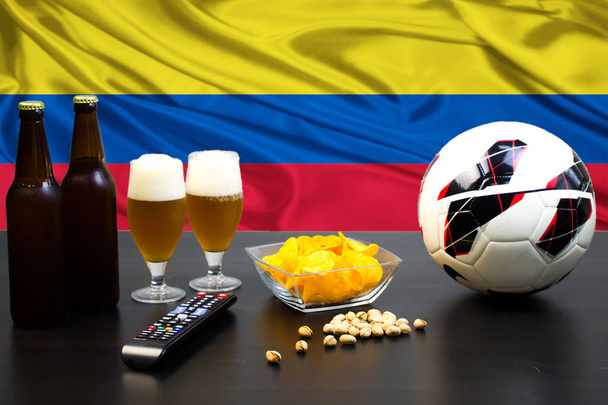 2 bottiglie di birra, 2 bicchieri di birra accanto al calcio sullo sfondo della bandiera della Colombia
. - Foto, immagini