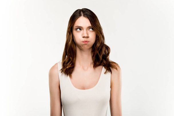 portrait of young woman with sad facial expression standing on white background - Foto, afbeelding