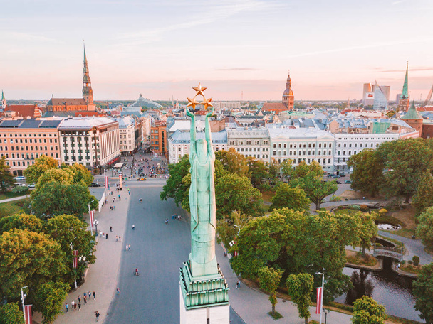 June 10, 2018. Riga, Latvia. Beautiful aerial view of the statue of liberty Milda in the center of the old town during amazing evening sunset view. - 写真・画像