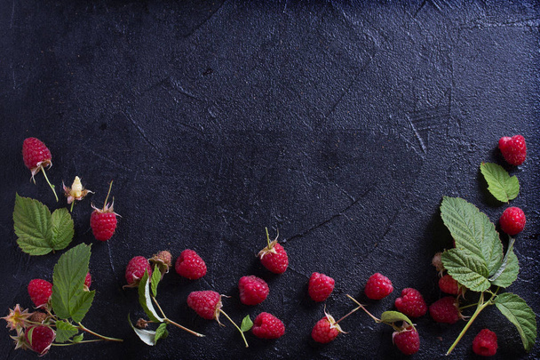 Raspberries on black background. Fresh ripe sweet berries. Selection of healthy food. Slate banner background. View from above, top studio shot, room for text - Foto, Bild