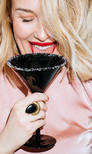 Beautiful blonde Caucasian woman having fun drinking cocktal. - Foto, imagen