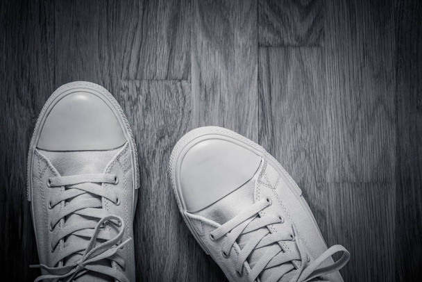 スポーツで灰色のファッショナブルな靴の 1 つのペア空寄木細工の床床の抽象的な背景のクローズ アップをスタイルします。 - 写真・画像