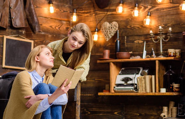 Mother and daughter doing homework. Woman and teenage girl discussing interesting book. Pupil preparing for high school exams, home education concept. Family spending holidays in countryside cottage - Фото, зображення