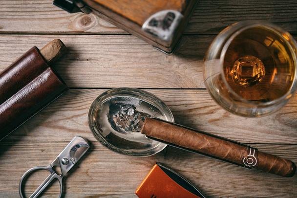 Cuban cigar and a glass of cognac brandy on wooden background, top closeup view - Photo, Image