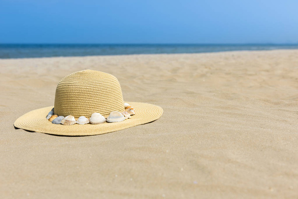 砂、貝殻、海で太陽から帽子。ビーチでの休暇の概念。コピー スペース. - 写真・画像