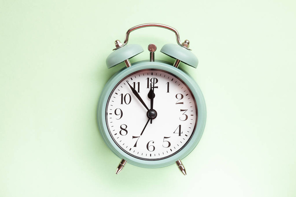 Reloj despertador de estilo retro sobre el fondo verde menta pastel
 - Foto, Imagen