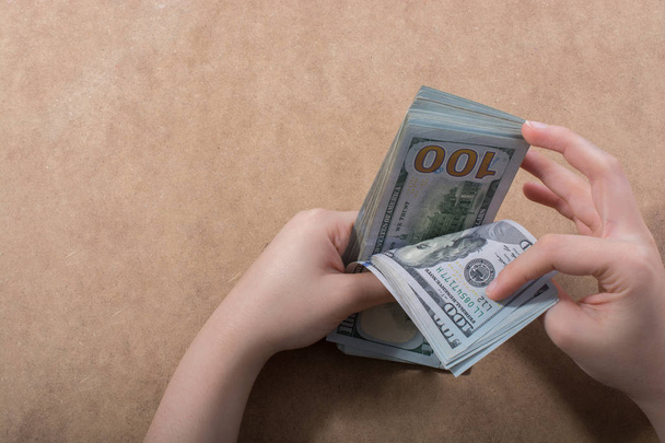 Hand hält amerikanische Dollarnoten isoliert auf Holzgrund - Foto, Bild
