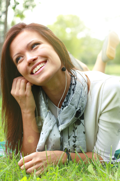 Beautiful Young Woman with Headphones Outdoors. Enjoying Music - Photo, image