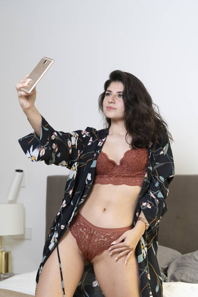 Sexy girl taking a self portrait in bedroom - Photo, Image