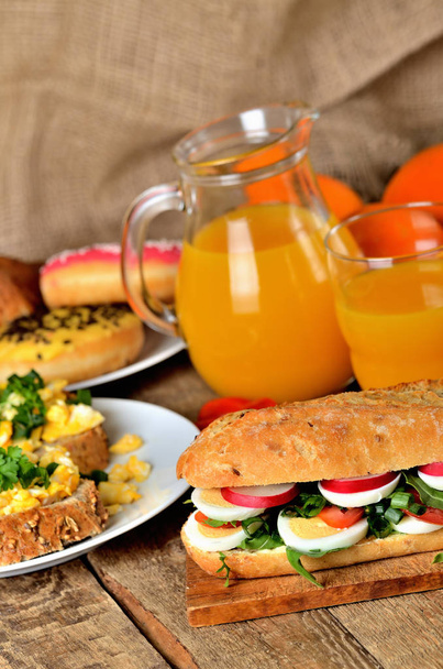 Stokbrood sandwich met ei, radijs, salade van rucola en tomaten - Foto, afbeelding