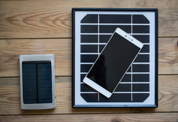 solar panel and smaptphone on the wooden table - Foto, imagen