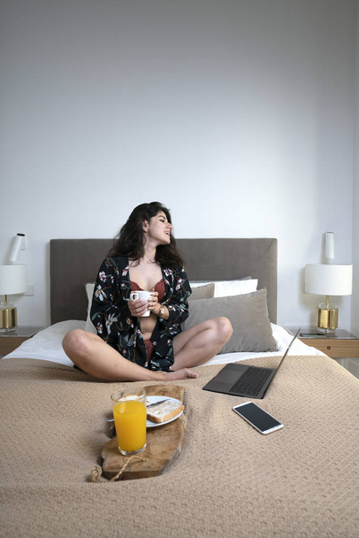 Girl in underwear having breakfast and using laptop in bed - Fotoğraf, Görsel