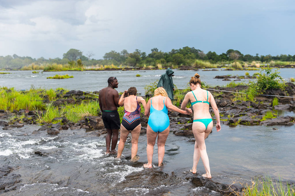 LIVINGSTONE ISLAND, ZAMBIA - JAN 14, 2016:  Unidentified tourists are going to swim in the Zambezi river on the Livingstone Island, named after the Scottish  explorer David Livingstone, - Фото, зображення