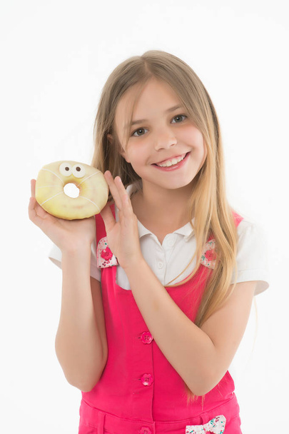 Small girl with donut isolated on white. Candyshop concept. Childhood and happiness. Happy child hold glazed ring doughnut. Kid smiling with junk food. Sweet mood. Unhealthy eating and snack food - Fotó, kép